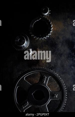 Metal gears lying on dark surface Stock Photo
