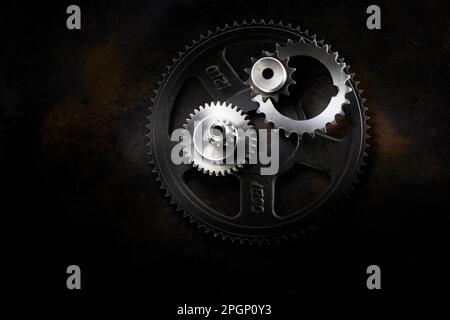 Metal gears lying on dark surface Stock Photo