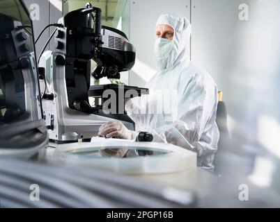 Technician using microscope working in laboratory Stock Photo
