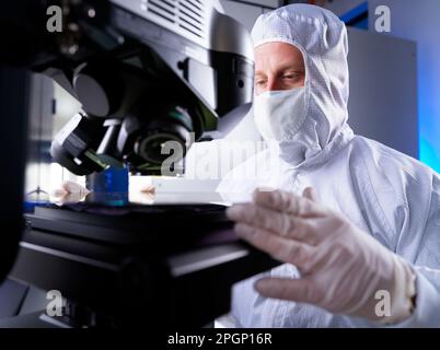 Engineer checking silicon wafer chip using semiconductor in laboratory Stock Photo