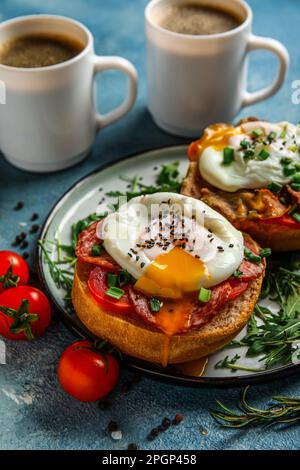 Plate with tasty eggs Benedict on blue background Stock Photo