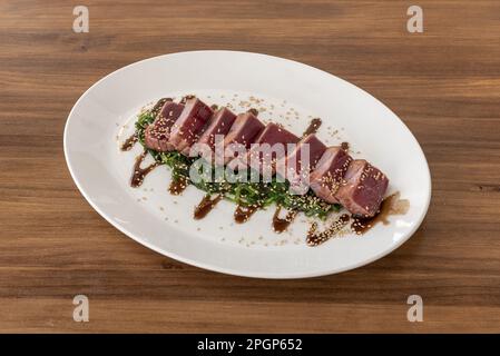 The tuna meat is briefly cooked on a flame or pan. The pieces are lightly marinated in vinegar and ginger. Finally the pieces are filleted Stock Photo