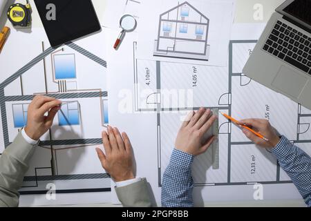Architects working with construction drawings at table, top view Stock Photo