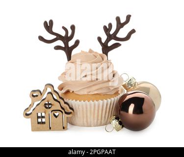 Delicious cupcake with chocolate reindeer antlers and Christmas decor on white background Stock Photo