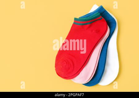 Socks of different colors on yellow color background. Stock Photo