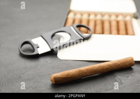 Cigars and guillotine cutter on black table Stock Photo