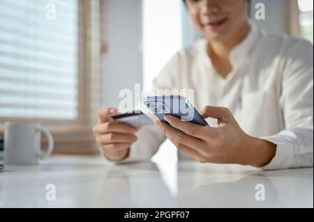 Close-up and selective focus image, An Asian man using mobile banking application to transfer money or pay online shopping bills. Stock Photo
