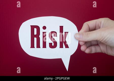 Speech bubble in front of colored background with Risk text. Stock Photo