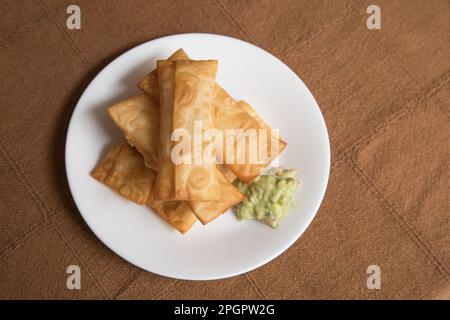 Tequenos deep fried dough and cheese fingers fast food snack with guacamole Peruvian venezuelan food Stock Photo