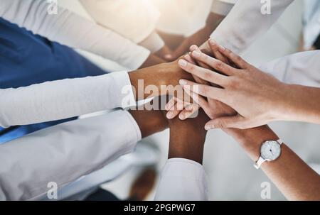 Lifesaving hands are skilled hands. a group of doctors joining their hands in solidarity at a hospital. Stock Photo
