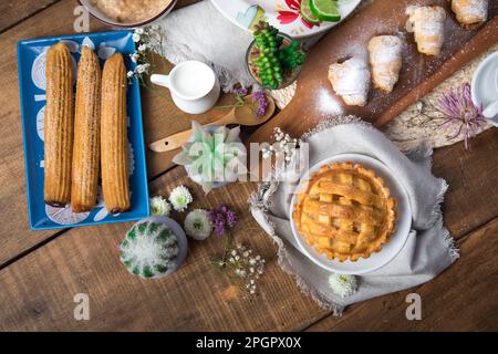 Churros and apple pye Peruvian desserts buffet table brunch sweet food Stock Photo