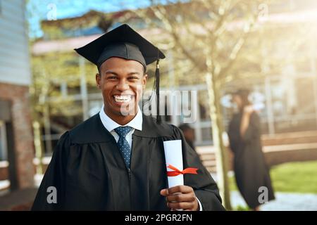 The future sure looks bright from here. Portrait of a happy young man holding a diploma on graduation day. Stock Photo