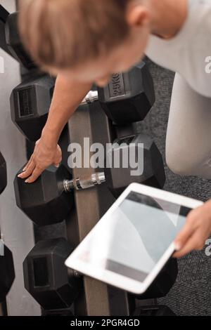 Fitness, woman and tablet mockup for weightlifting tutorial, exercise or schedule workout and planning at the gym. Hands of active female with Stock Photo