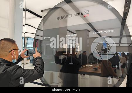 SHANGHAI, CHINA - MARCH 24, 2023 - Customers try Huawei's new P60 and Mate X3 foldable phones at the Huawei global flagship store on Nanjing Road Pede Stock Photo