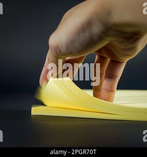 Stack of yellow colored paper with hand on frame Stock Photo