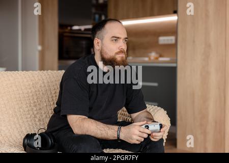 Male gamer playing on console in his home. Stock Photo