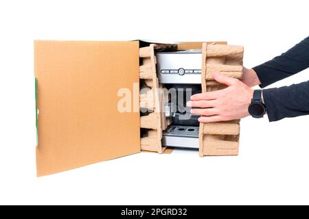 Male hands taking a brand new sleek and stylish carob espresso coffee machine out of the retail box isolated on white background. Stock Photo