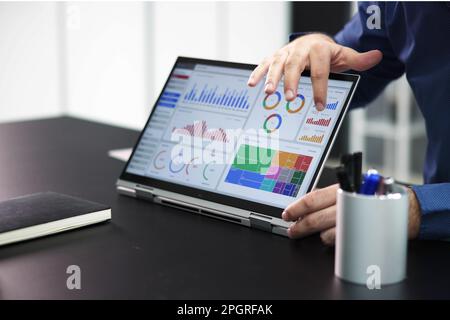 Two Businesspeople Analyzing Financial Graph On Laptop Stock Photo