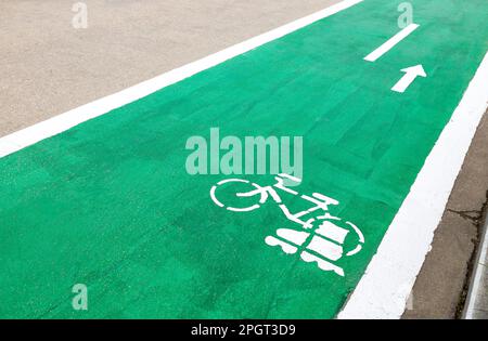 Dedicated green cycleway with bicycle and roller skates sign, designed to make cycling safer on the asphalt road Stock Photo