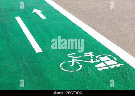 Dedicated green cycleway with bicycle and roller skates sign, designed to make cycling safer on the asphalt road Stock Photo