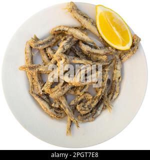 Spanish snack of batter fried anchovies served with lemon Stock Photo