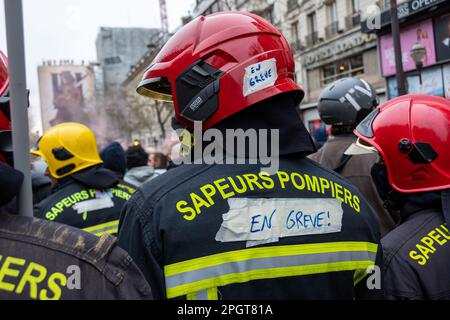 Striking French firefighters in fire gear seen from behind during a protest against the retirement reform in France Stock Photo