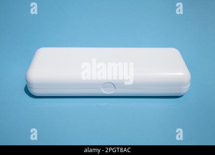 White rectangular plastic box with copy space isolated on blue. Smooth shiny case with a lid for a product mockup Stock Photo