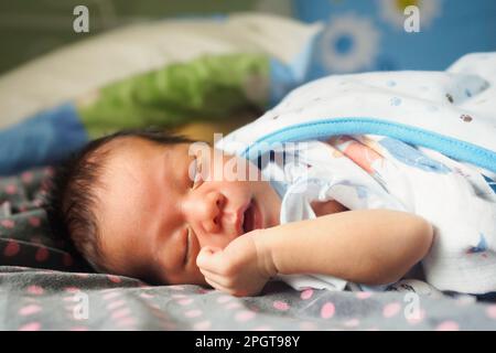 Happy cute asia newborn baby boy sleeping in children bedroom at the morning with copy space. family and health care concept Stock Photo