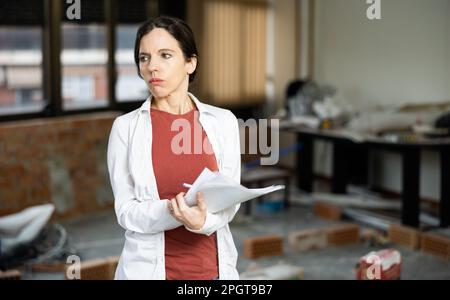 Interested brunette making notes while planning home renovation Stock Photo