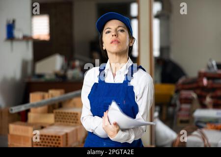 Female contractor taking notes while planning building renovation Stock Photo