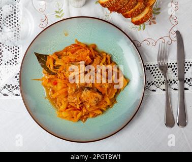 Plate of stewed cabbage with pork ribs and carrot in cafeteria Stock Photo