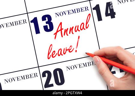 13th day of November. Hand writing the text ANNUAL LEAVE and drawing the sun on the calendar date November 13. Save the date. Time for the holidays. v Stock Photo