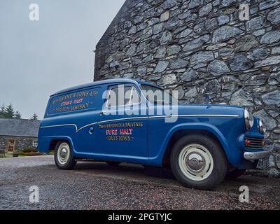 Dufftown, Scotland - 05 22 2018: blue vintage car in front of the popular and traditional Glenfiddich distillery in Scotland. Stock Photo