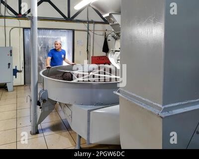 Naranjo, Costa Rica - A worker oversees coffee beans roasting at the Espiritu Santo coffee farm and processing plant. Stock Photo