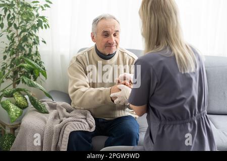 Upset older man listening to supportive speech of pleasant female doctor, head shot close up. Middle aged kind medical specialist old male patient Stock Photo