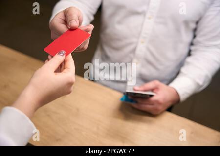 Businessperson getting key card from female receptionist Stock Photo
