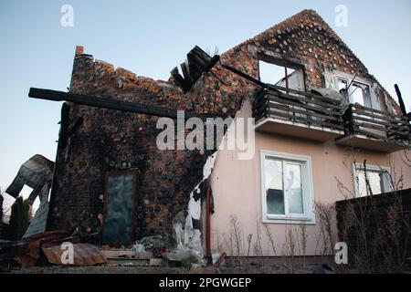 Destroyed building after russian invasion, Ukraine. Ruined facade of house. War in Ukraine. Broken windows and brick walls after missile attack. Stock Photo