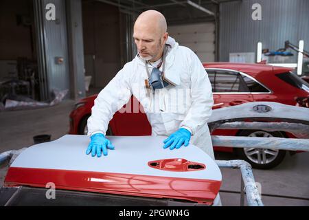 Middle-aged man at the workplace is engaged in car repairs Stock Photo