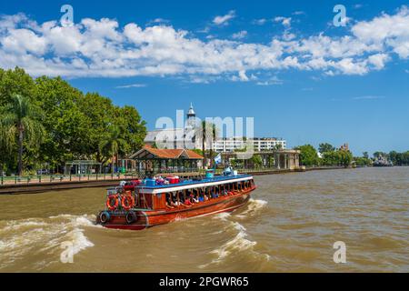 Tigre, Argentina - 7 February 2023: Mahogany boats ferry passengers past the Museo de Arte Tigre building Stock Photo