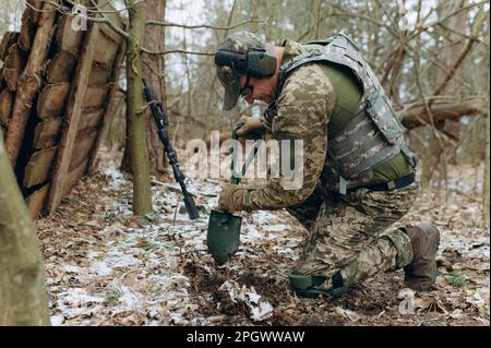 a soldier with a shovel in his hand digs the ground. Stock Photo