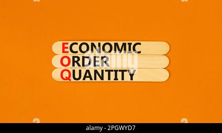 EOQ economic order quantity symbol. Concept words EOQ economic order quantity on wooden stick on a beautiful orange table orange background. Business Stock Photo