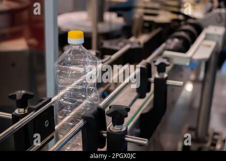 Empty pet sunflower oil bottle with yellow cap on conveyor belt Stock Photo