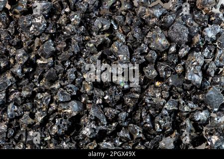 Coarse basalt sand, Kalapana, Hawaii. Rain falling on the hot surface of a lava flow caused it to shatter. It's iridescent and glassy characteristics Stock Photo