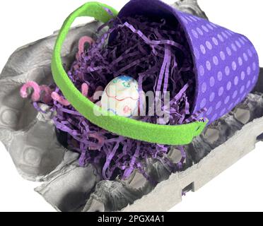 Purple Easter basket with child hand decorated egg and purple paper grass rests on an empty egg caring. Use handle for text space. Isolated image. Stock Photo