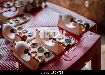 DIY white Easter eggs with watercolor painting tools on red table. Handmade Easter eggs decoration. Stock Photo
