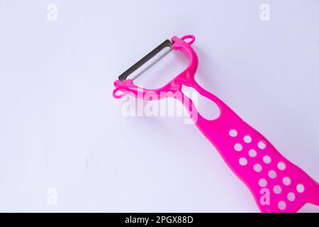 pink plastic peeler on white background Stock Photo