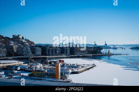 Oslo, Norway - March 11, 2023: People looking at the beautiful Oslo cityscape from the Opera house roof. Stock Photo