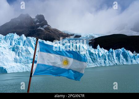 An Argentina flag on a tour boat with Upsala glacier in the background. Stock Photo