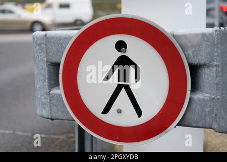 red white road sign passage prohibited with road traffic in blurred background Stock Photo