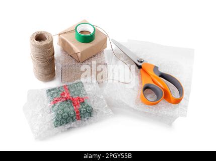 Cardboard boxes, bubble wrap, scissors and adhesive tape on white background Stock Photo